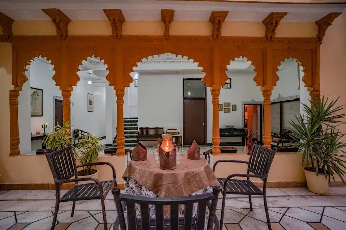 Traditional Rajasthani heritage sitting area featuring intricately carved wooden arches, elegant seating, decorative interiors and a warm royal ambience at The Lavitra, Udaipur.