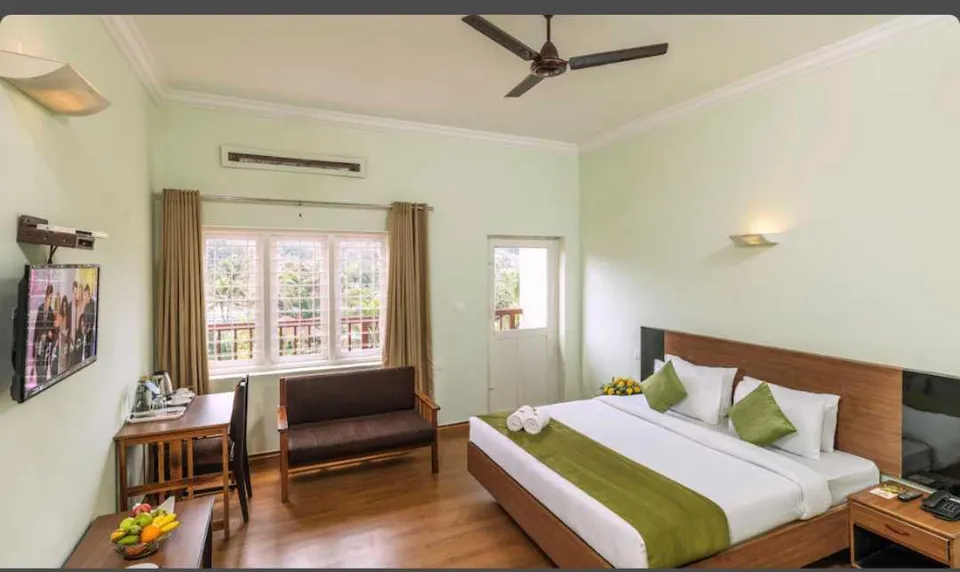 Elegant guest room at The Cardamom Thekkady with comfortable bedding and modern amenities.