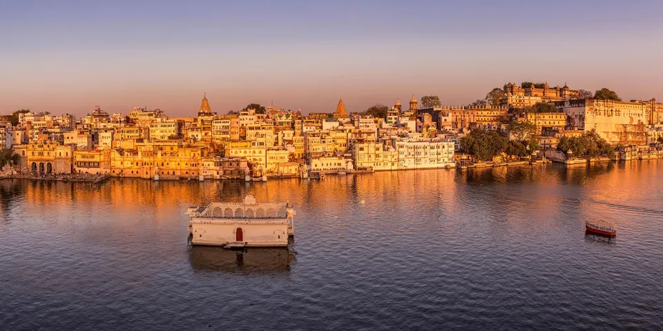 Udaipur's Lake Pichola with the iconic Lake Palace, historic City Palace and scenic Aravalli Hills in Rajasthan.