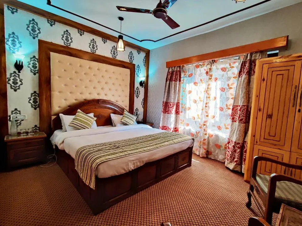 Comfortable guest room at The Shelter Heritage with cosy bedding, warm wooden furnishings and a relaxing ambience.