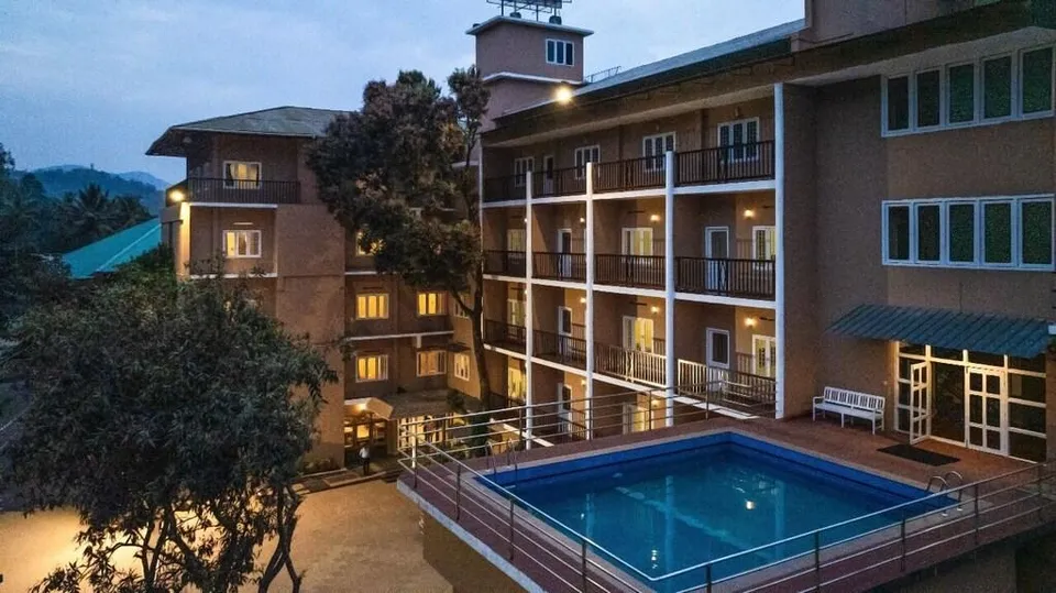 The Cardamom Thekkady hotel exterior with swimming pool and comfortable resort facilities.