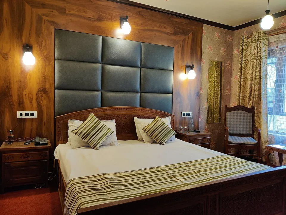 Well-furnished room interior at The Shelter Heritage featuring comfortable beds and practical amenities for a pleasant stay.