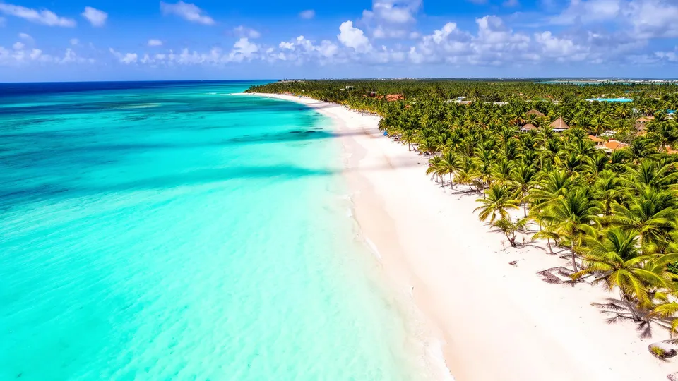 Beautiful tropical beach with turquoise waters, soft white sand and swaying palm trees.